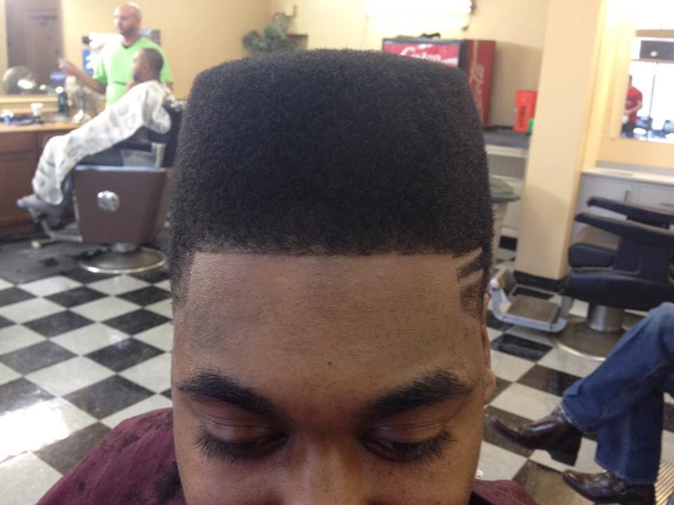 A man is getting his hair cut at a barber shop