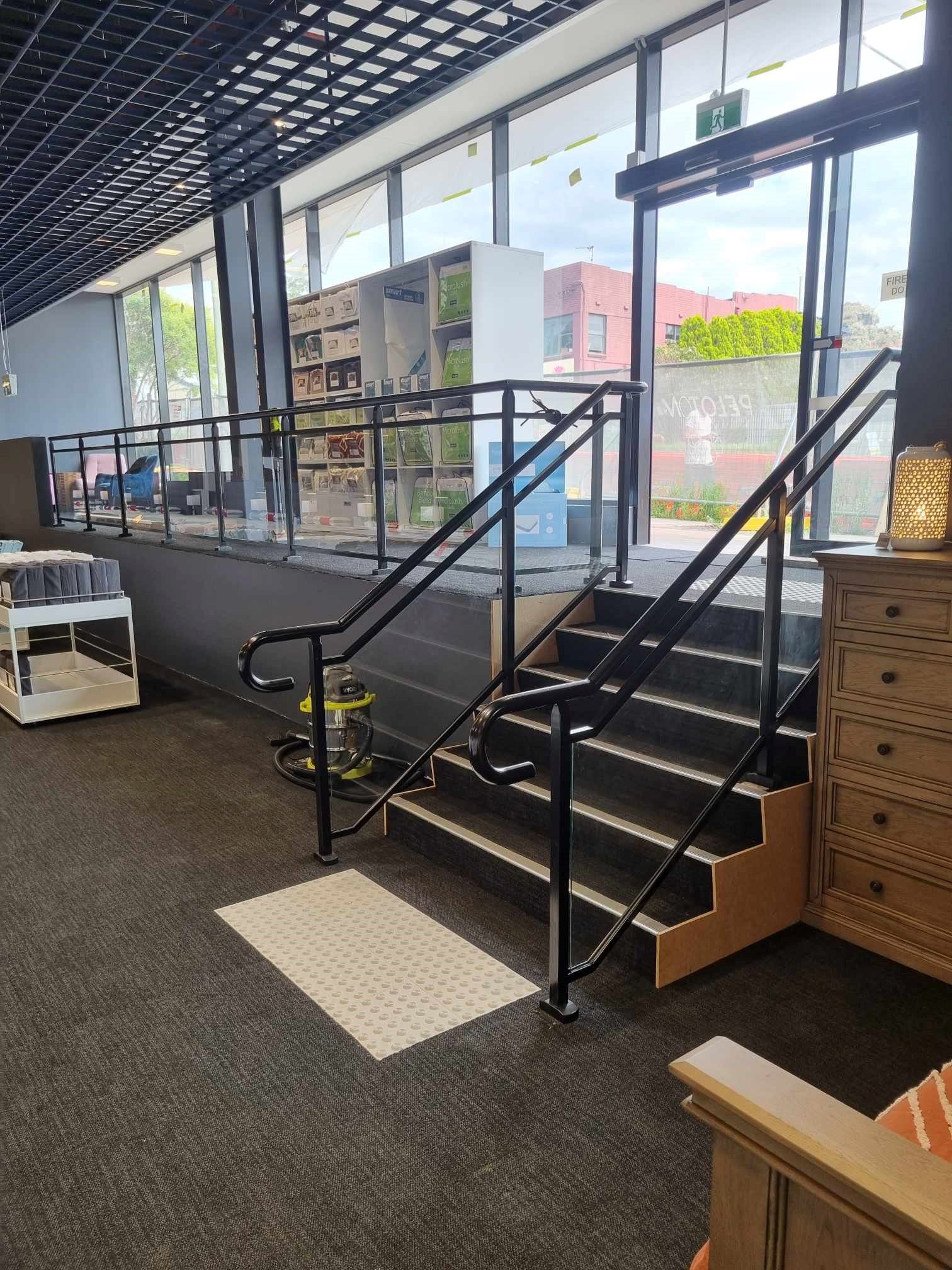 Stairs and ramp inside building with black handrails — D & T Balustrade Systems In Unanderra, NSW