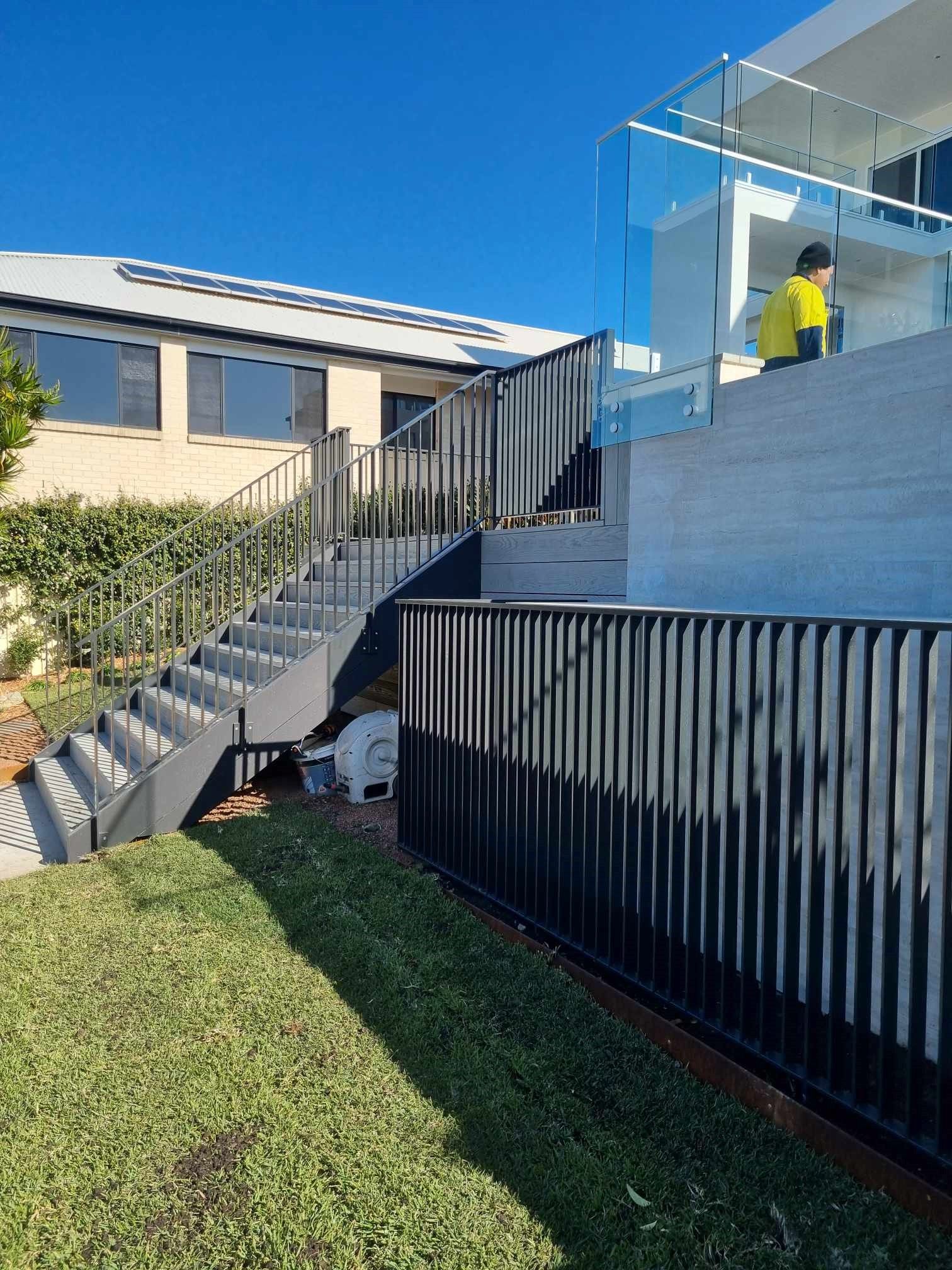 Metal staircase leading up to a modern building — D & T Balustrade Systems In Unanderra, NSW