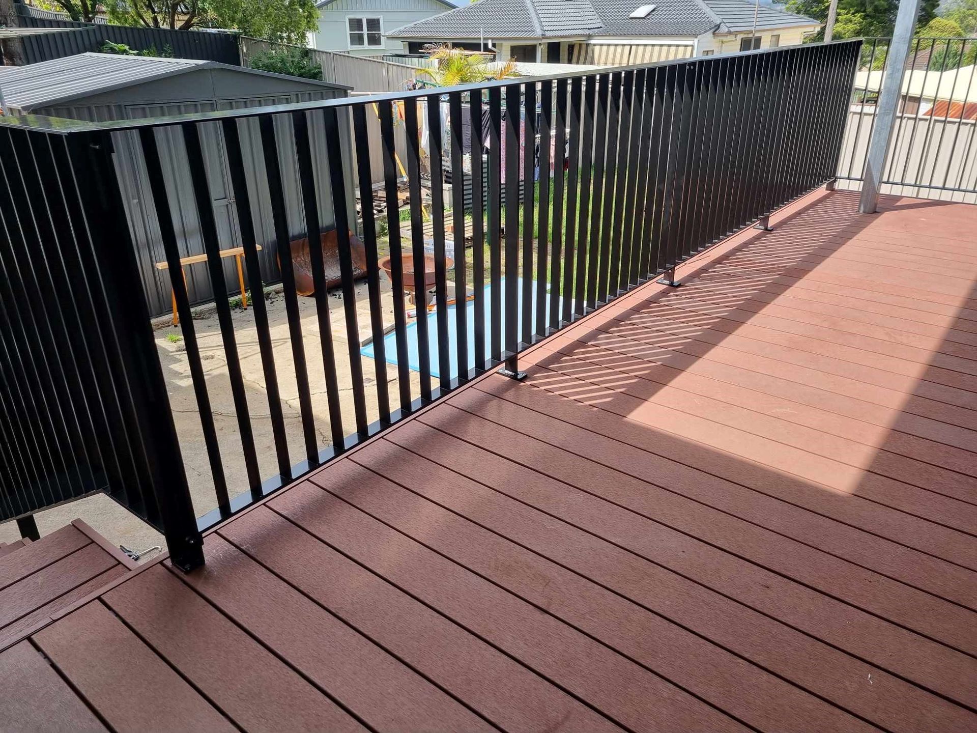 Brown deck with black vertical railing — D & T Balustrade Systems In Unanderra, NSW