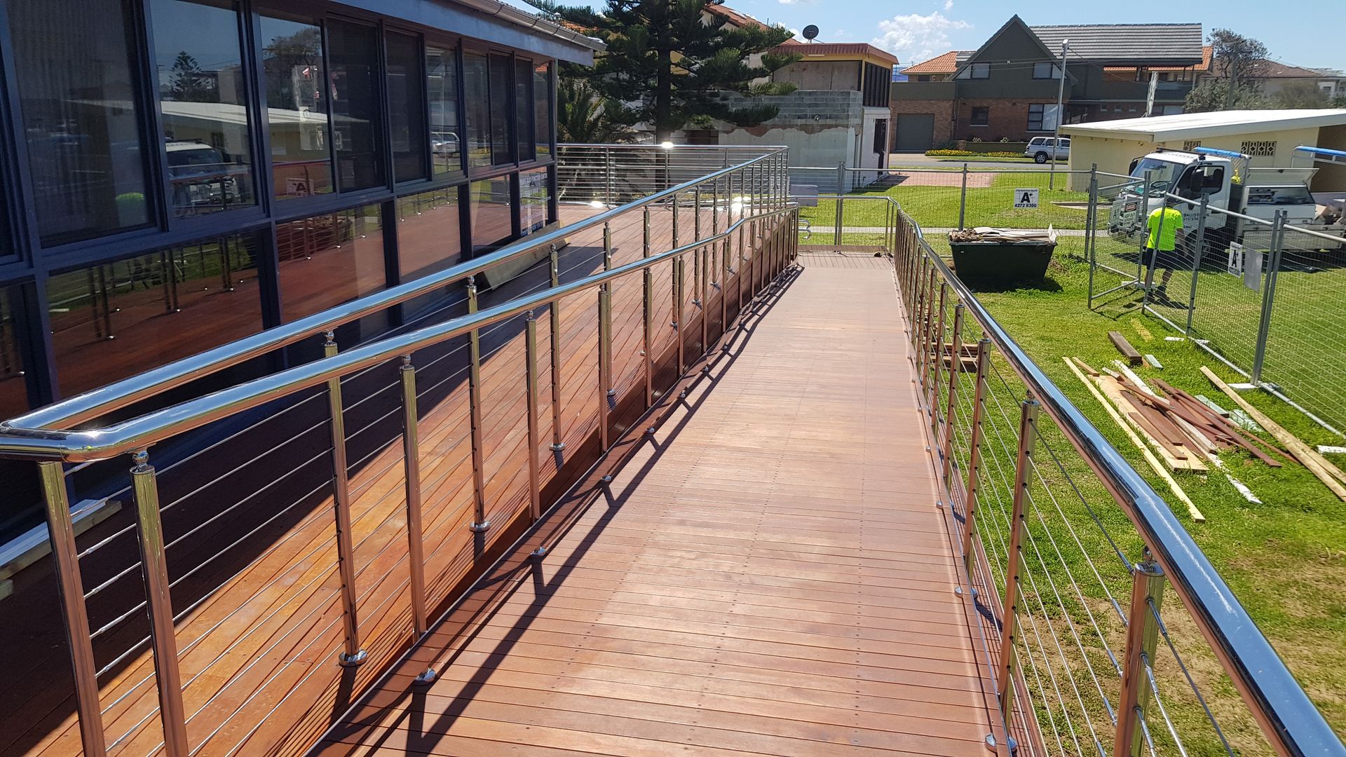 Metal handrail on exterior stairs against a light-coloured concrete wall — D & T Balustrade Systems In Unanderra, NSW