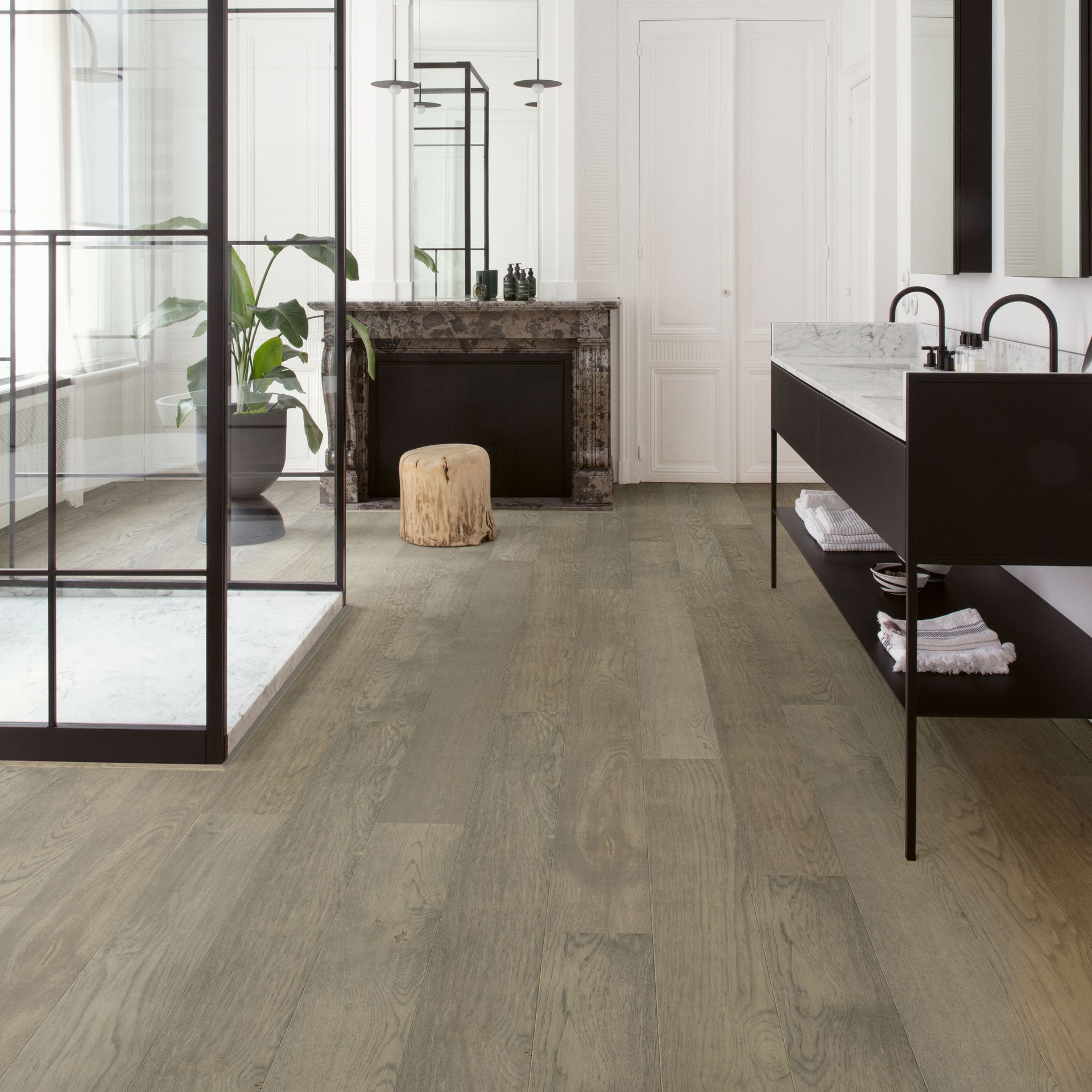 Bathroom with light gray wood-look flooring, glass shower, black vanity, and a decorative fireplace.