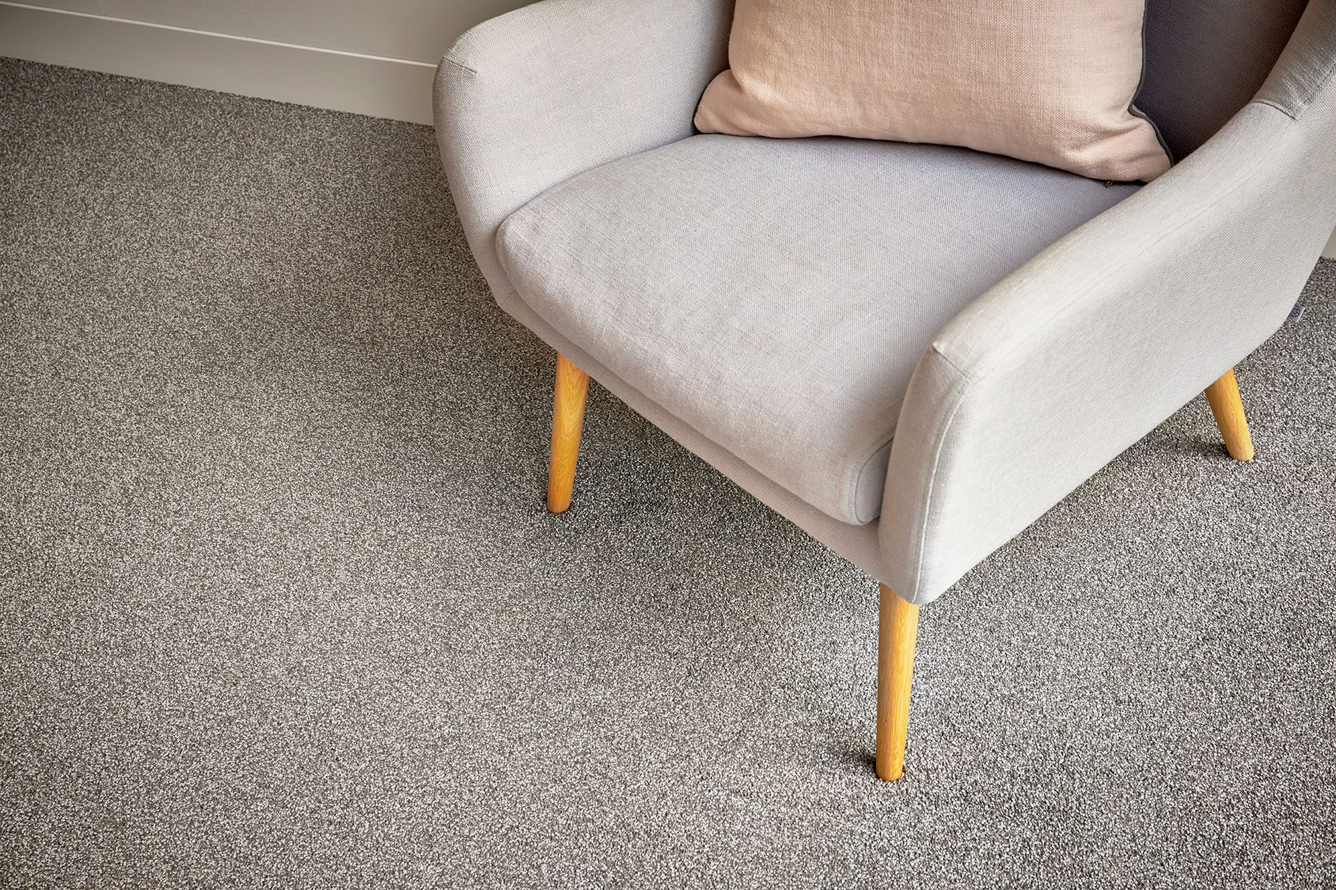 Grey armchair on a mottled carpet