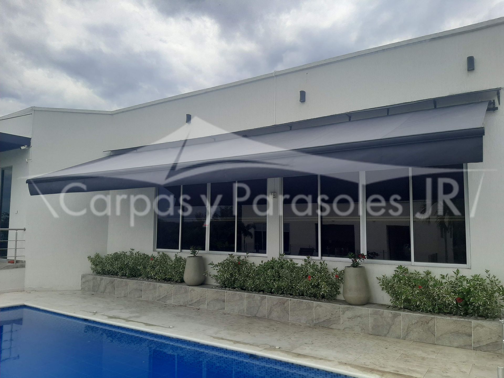 Una vela de sombra arquitectónica de color blanco se extiende sobre la terraza