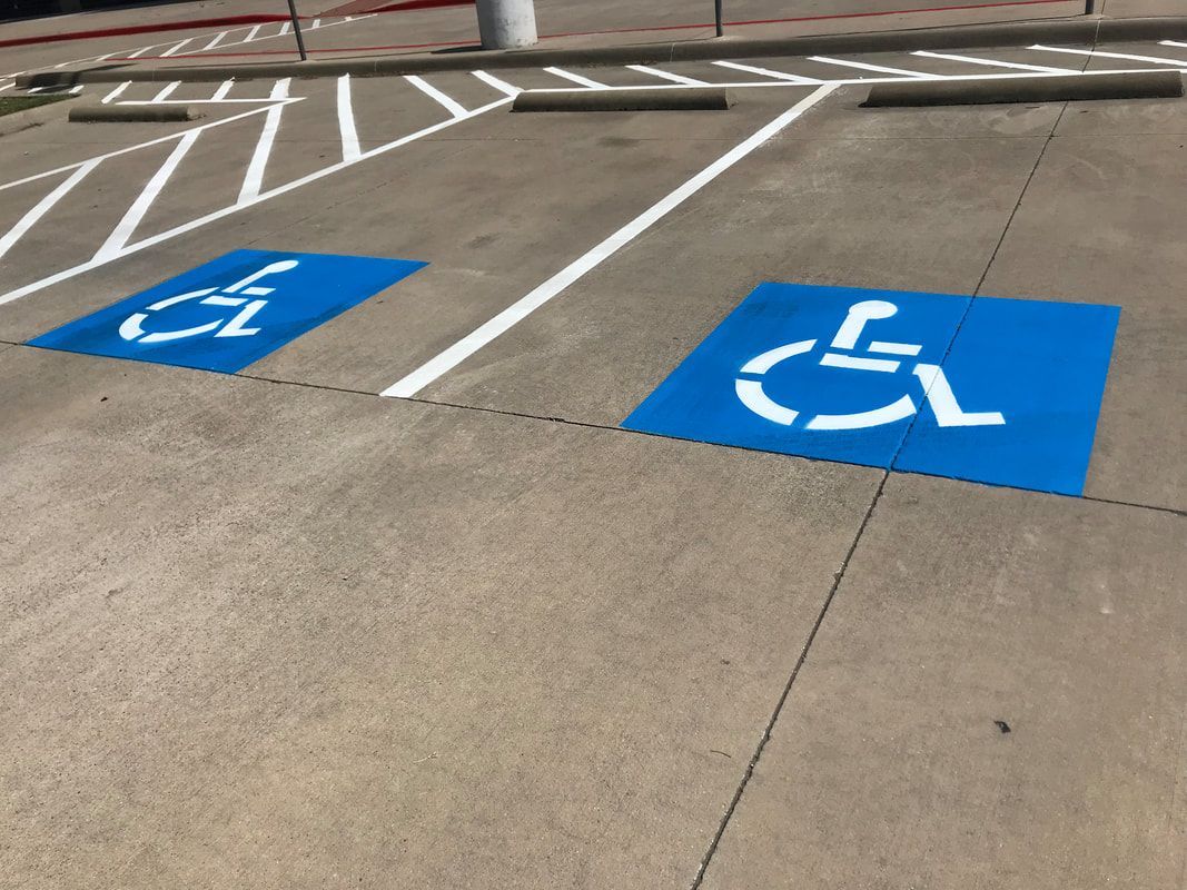 Blue accessible parking spaces painted on pavement in a parking lot.
