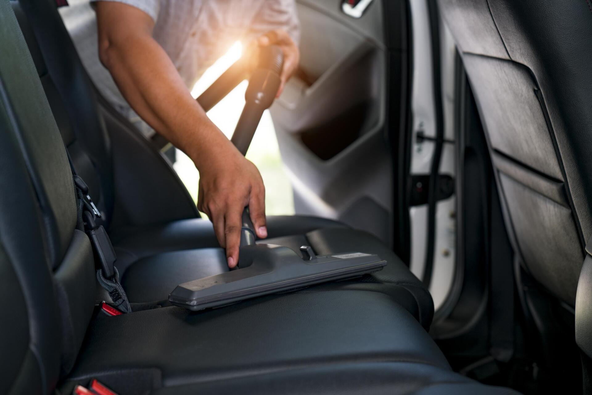 worker cleaning car interior