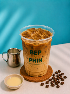 Two iced layered coffee drinks with straws on a wooden tray, on a tabletop.