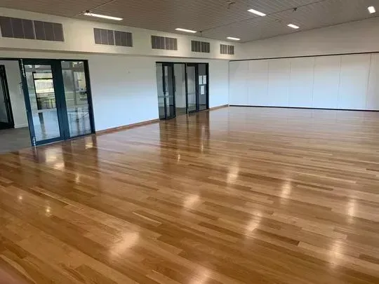 Hall 1 - with shiny wooden floor, white walls, glass doors, and air-conditioning.