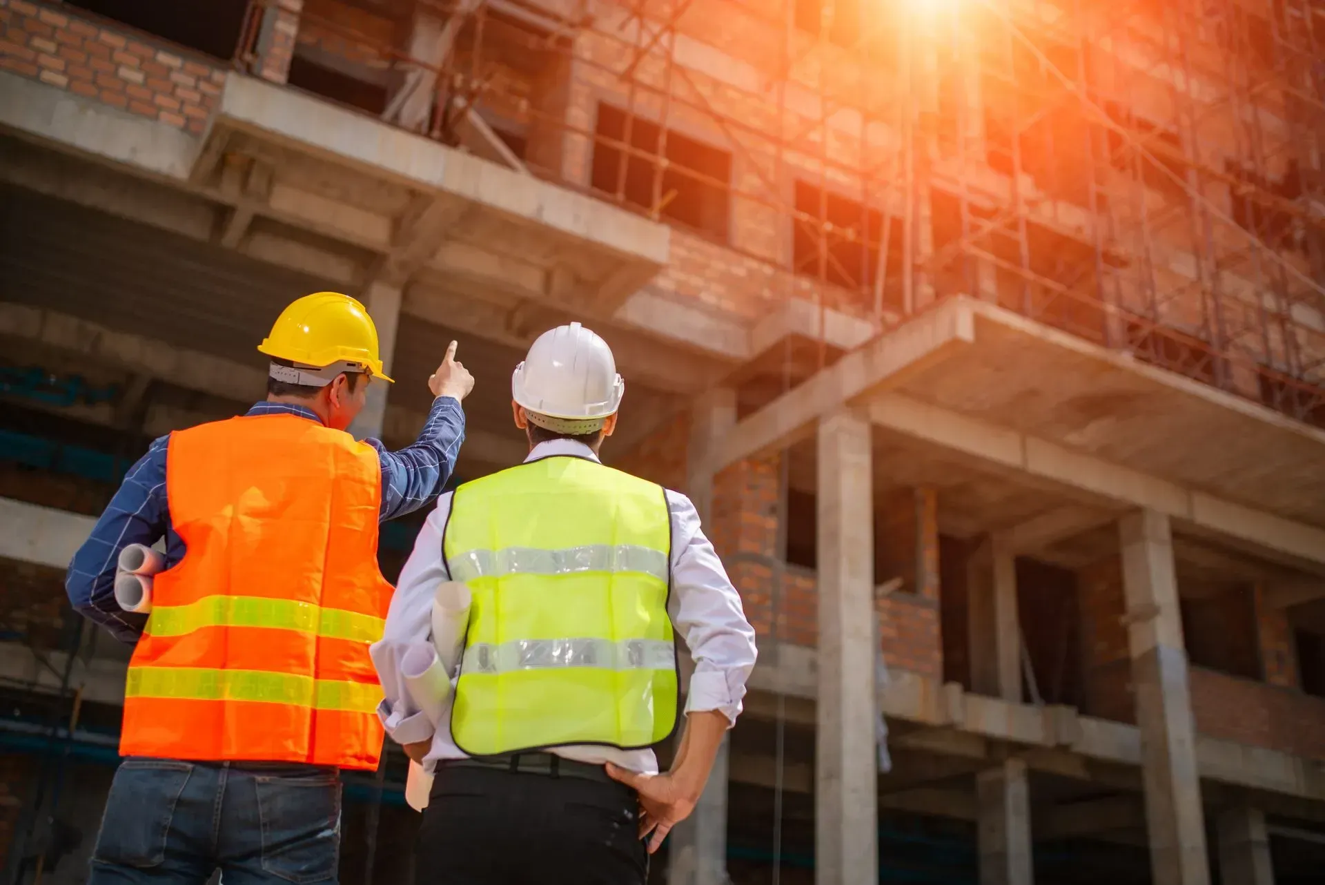 two engineers are standing in front of a building under construction