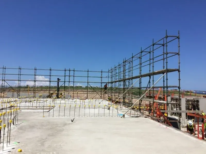A construction site with scaffolding and a blue sky in the background.