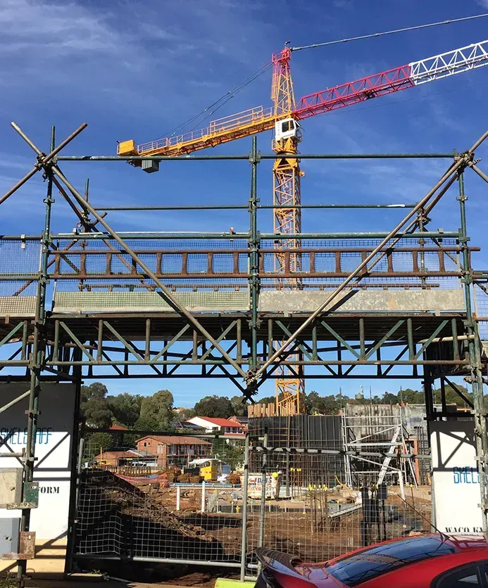 A construction site with scaffolding and a crane in the background