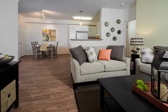 photo showing living room with the dining area and kitchen in the background