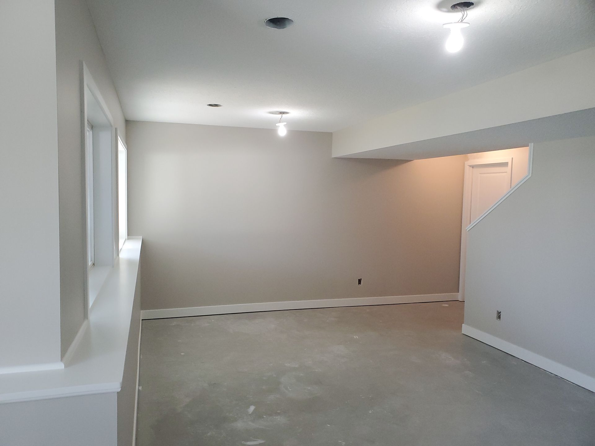 Empty beige room with unfinished floor and recessed ceiling lights