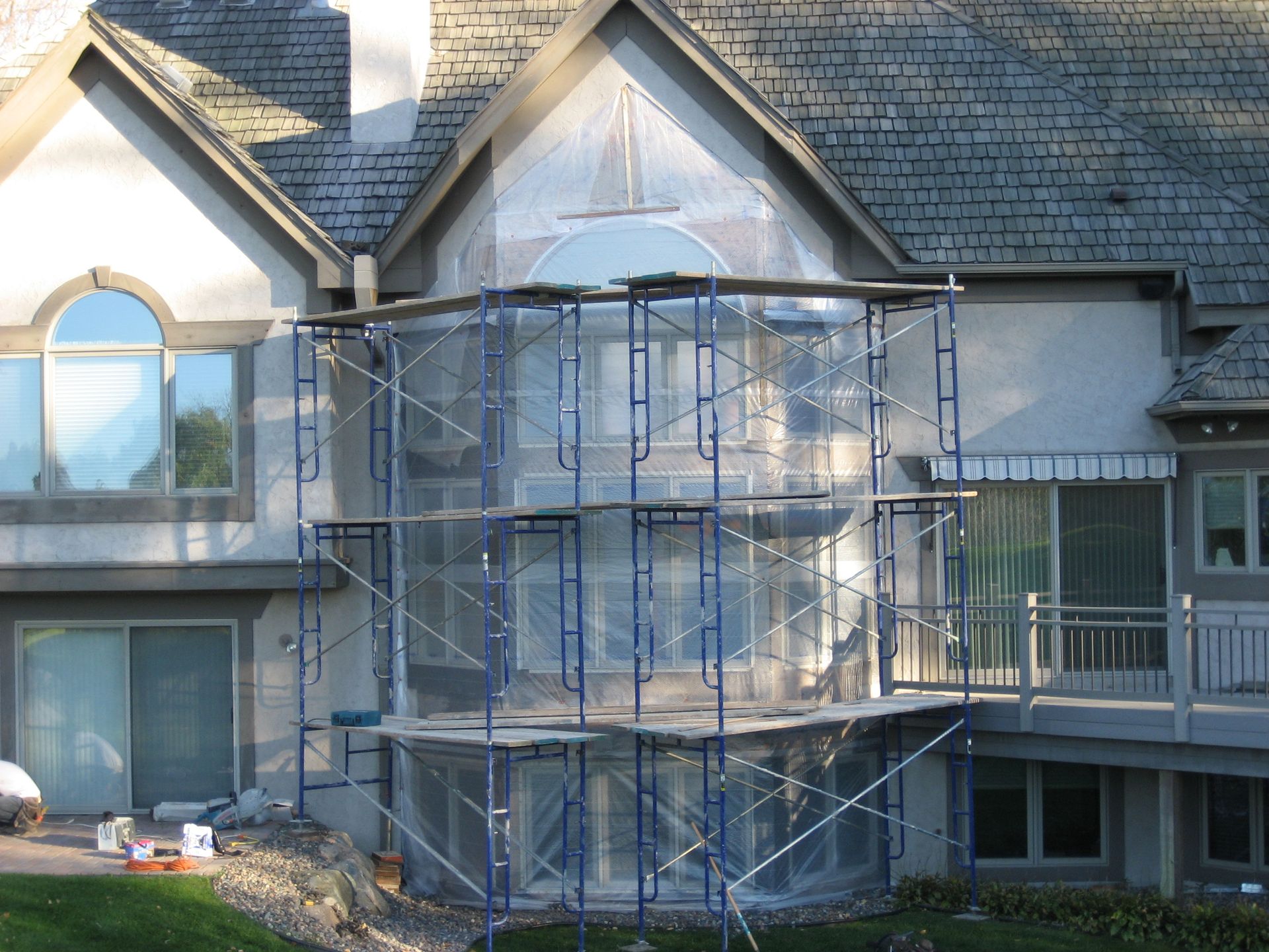 House exterior with metal scaffolding around the central entrance under construction