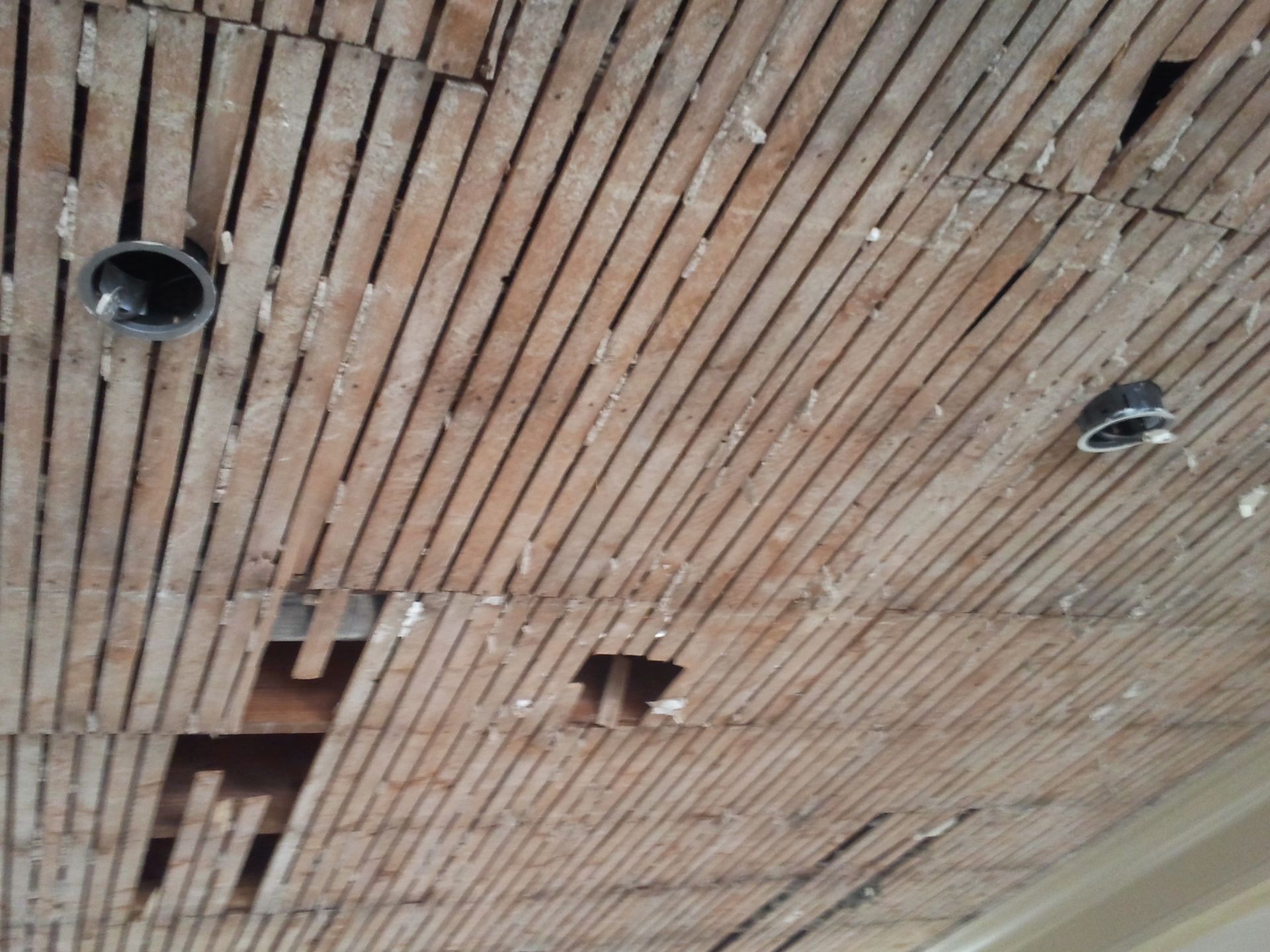 Wooden slatted ceiling with several recessed light fixtures and open rectangular cutouts