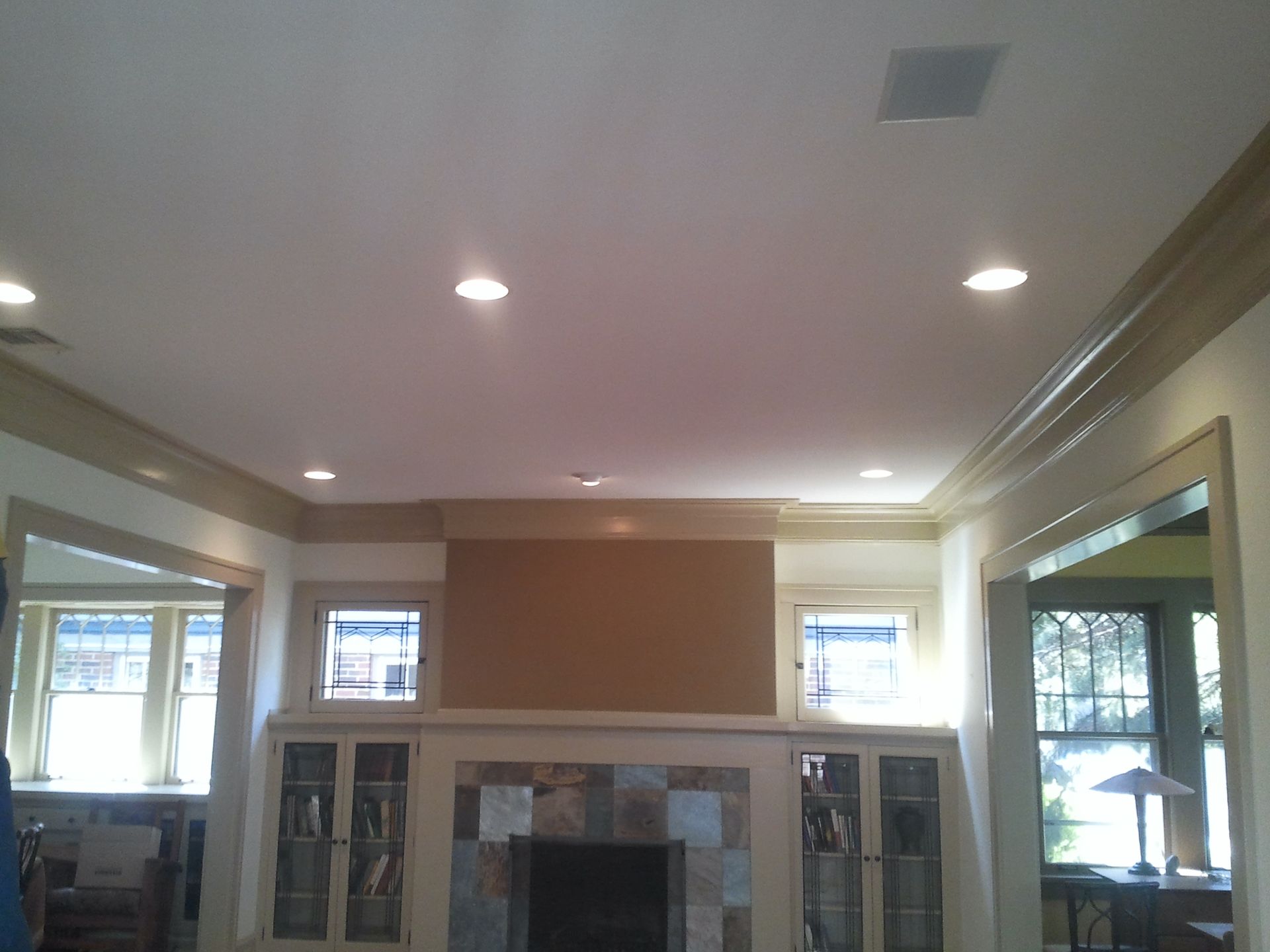 Living room with a stone fireplace, built-in cabinets, and recessed ceiling lights