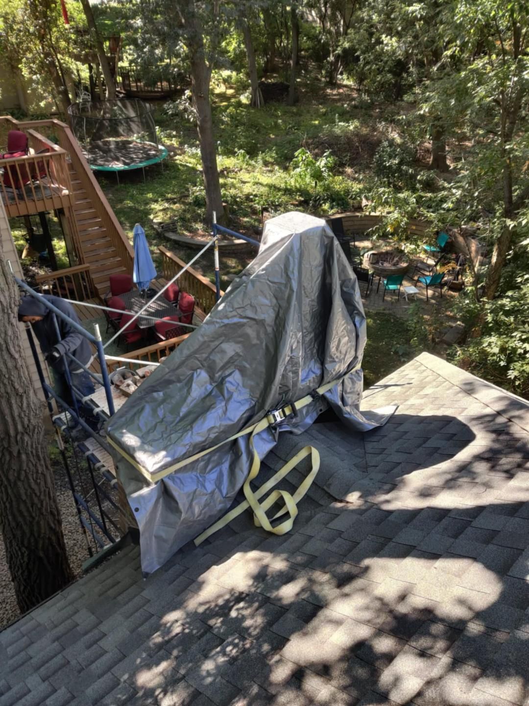 Covered stroller on a wooden deck in a wooded backyard