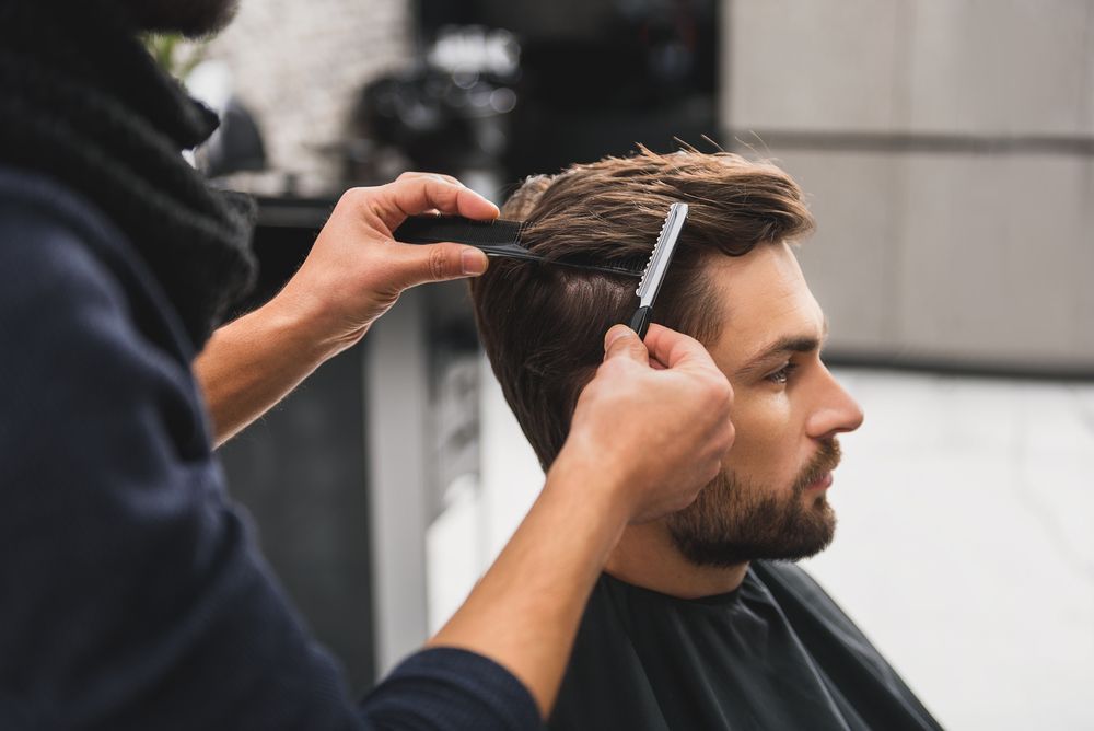 A Man Is Getting Her Hair Cut by a Hairdresser in a Salon — Barbarella Hair in Maryborough, QLD