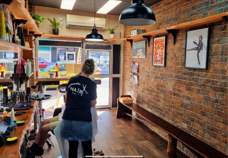 A Woman is Cutting a Man's Hair in a Barber Shop — Barbarella Hair in Maryborough, QLD