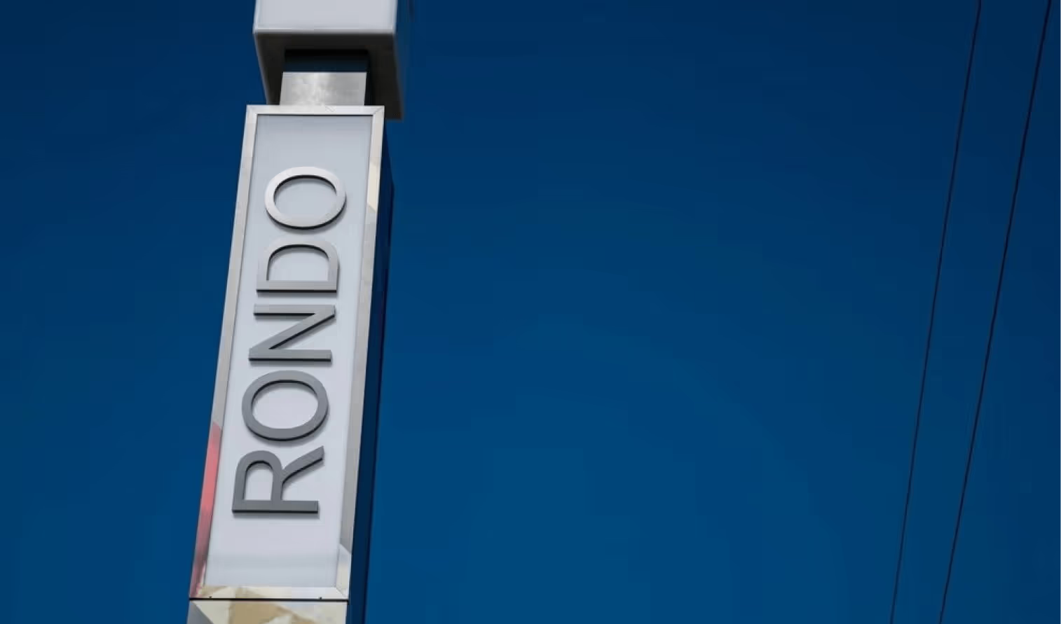 A white, vertical sign reading