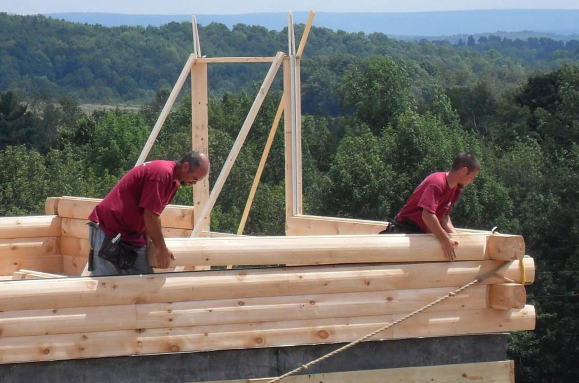 Two men are working on a wooden structure.