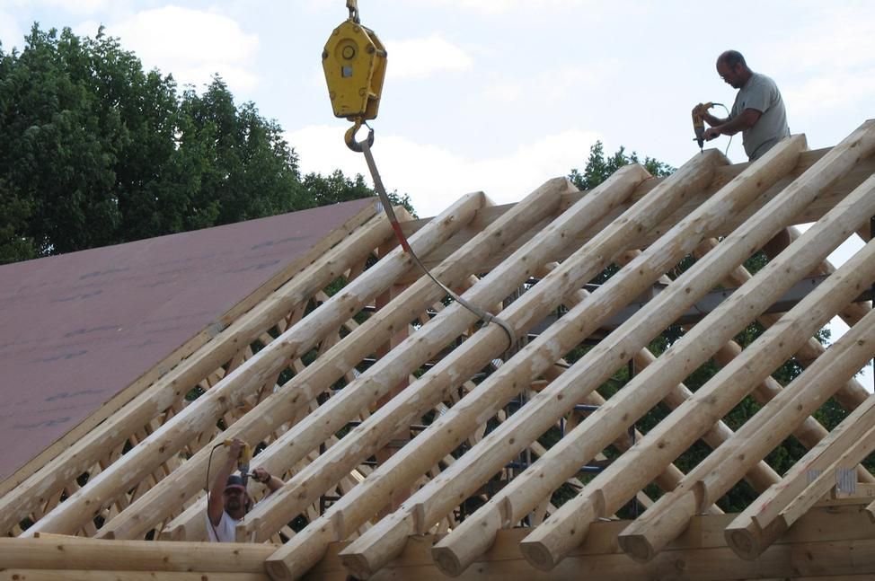 Two men are working on the roof of a building