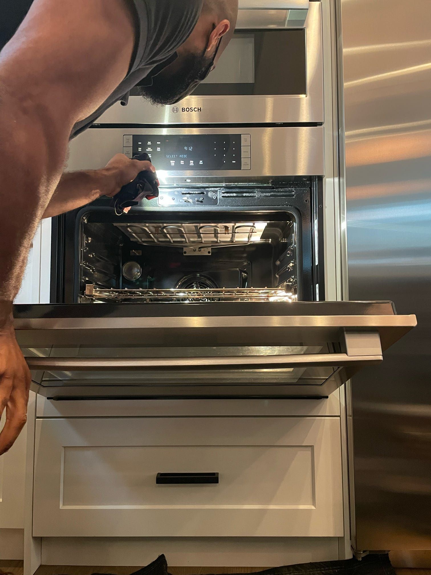 Oven repair specialist examining heating elements and temperature sensors during service call