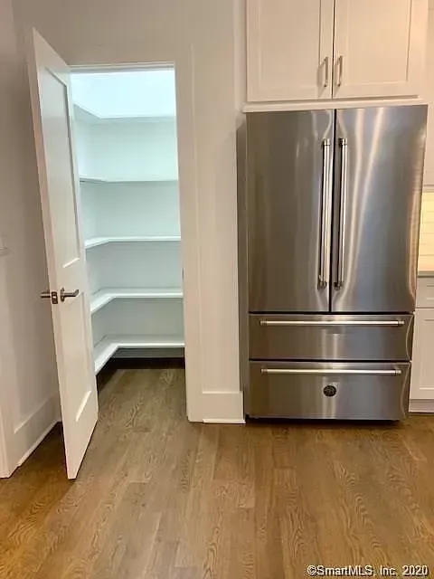 A kitchen with a stainless steel refrigerator and a pantry.