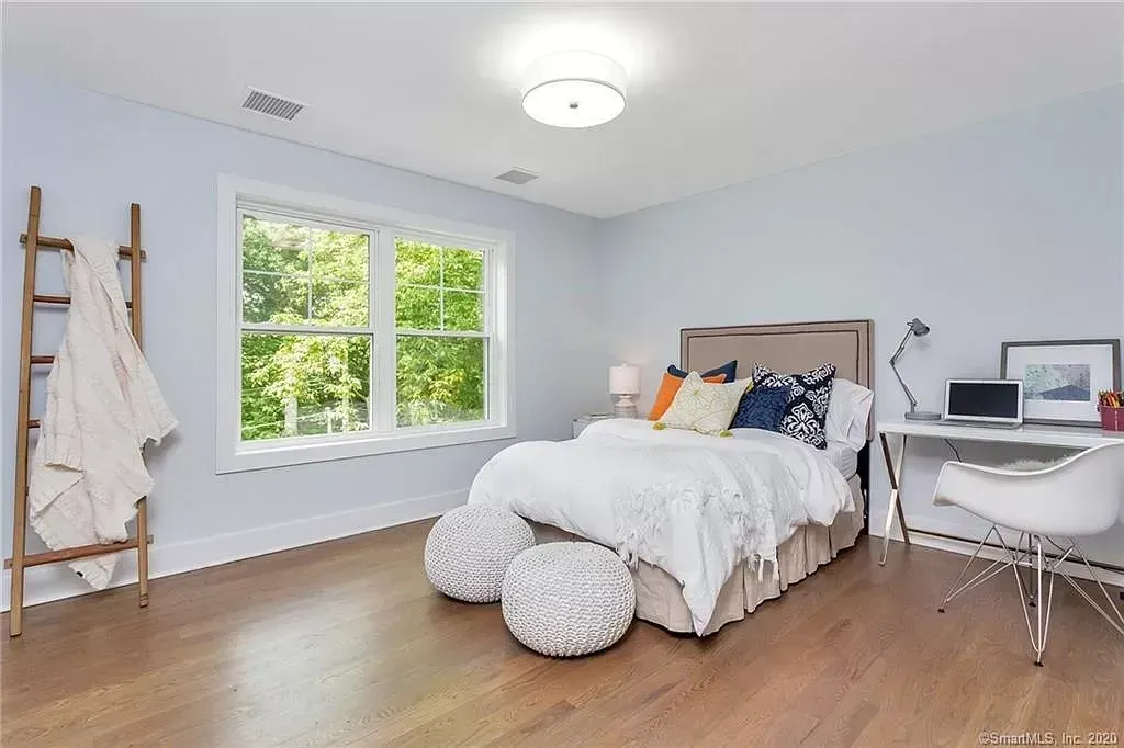 A bedroom with a large bed and a desk