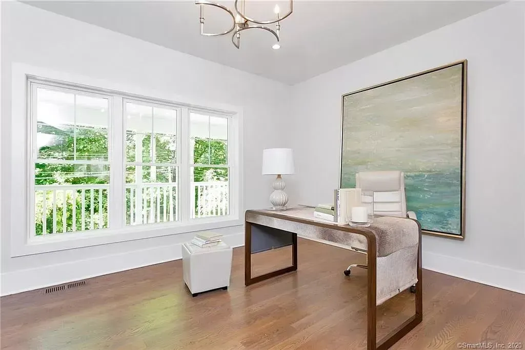 A room with a desk and a painting on the wall.