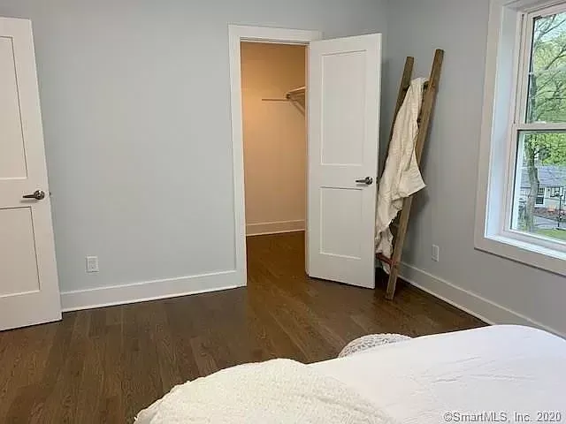 A bedroom with a bed and a walk in closet.