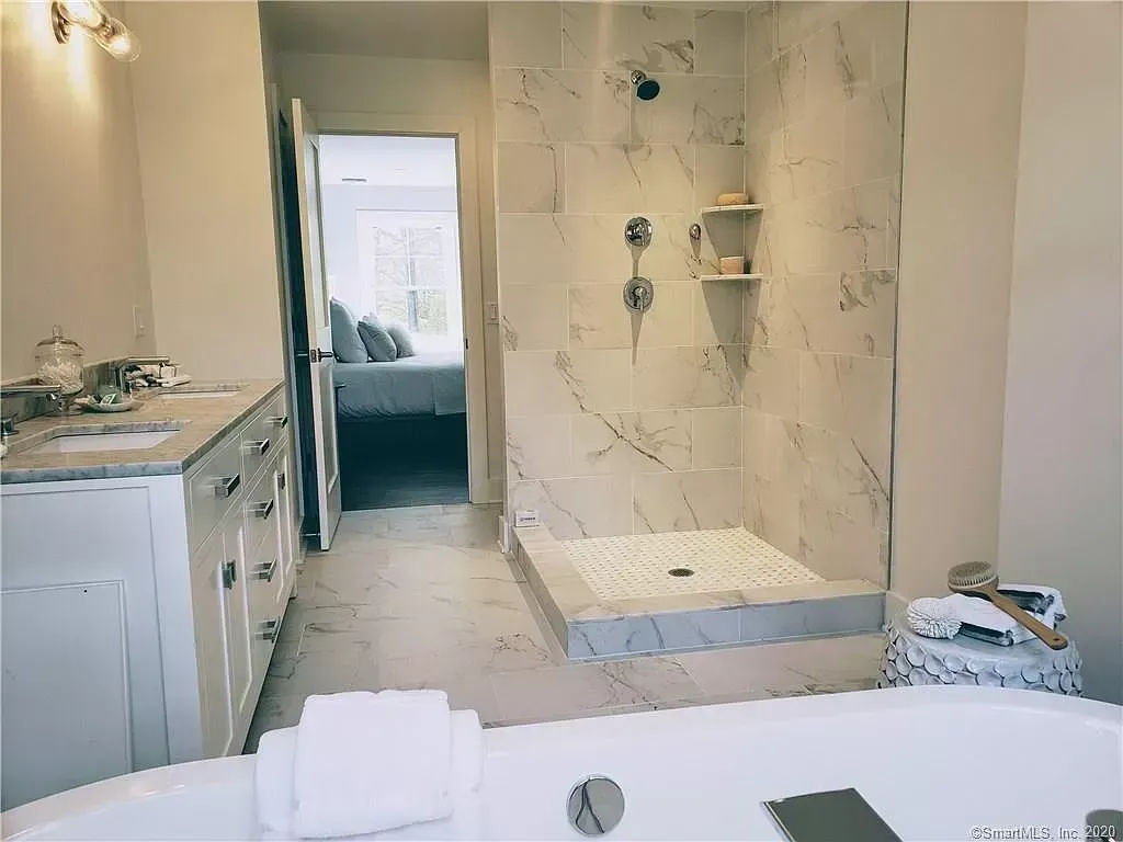 A bathroom with a tub , sink , shower and walk in shower.