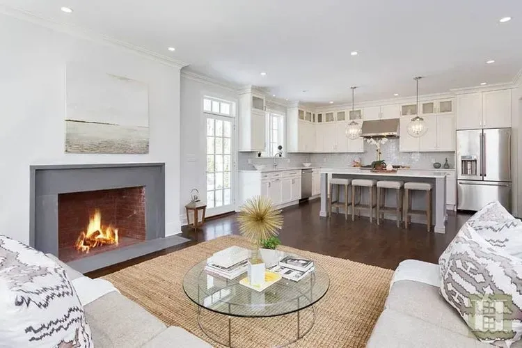 A living room with a fireplace , couch , coffee table and kitchen.
