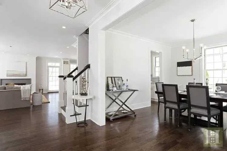 A living room with a table and chairs and a staircase