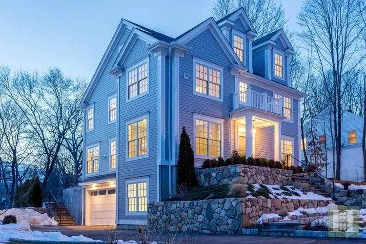 A large house with a lot of windows is lit up at night.