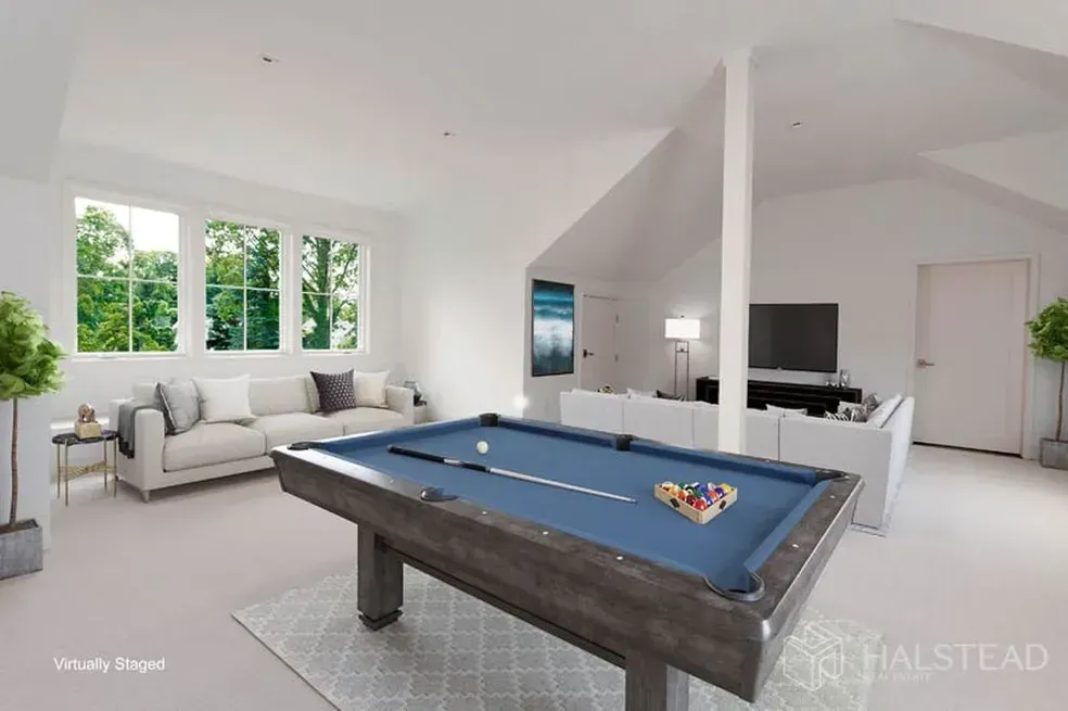 A pool table is in the middle of a living room.