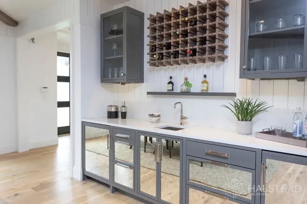 A kitchen with a wine rack on the wall and a sink.