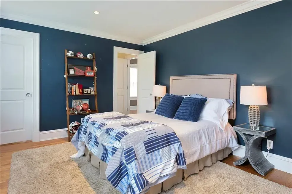 A bedroom with blue walls and a bed
