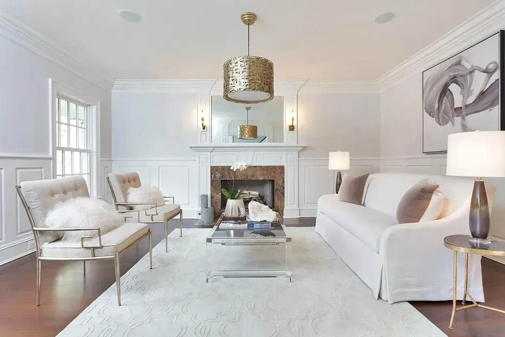 A living room with white furniture and a fireplace