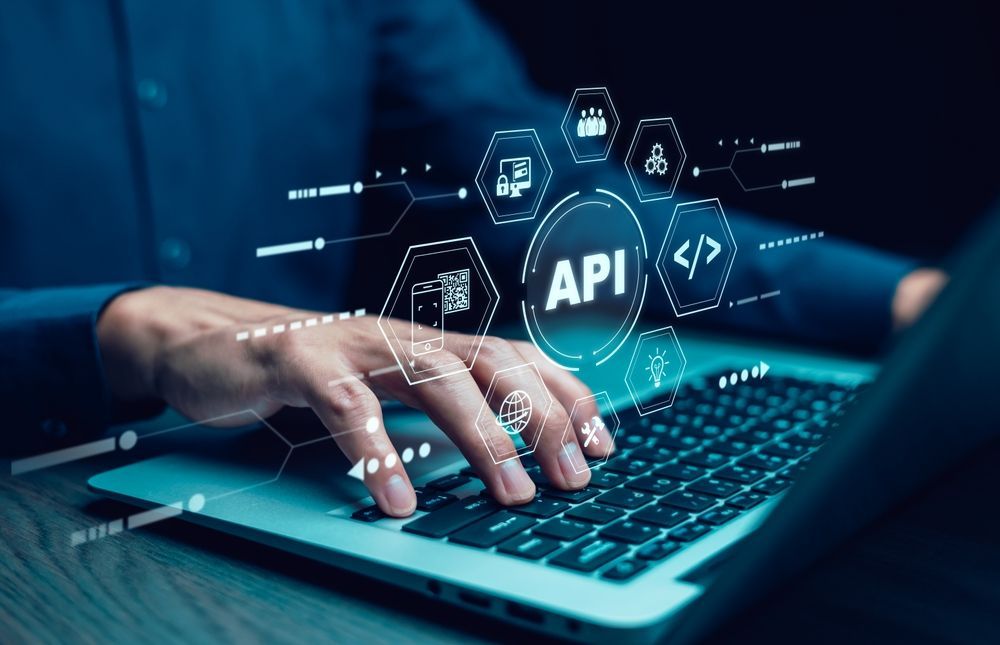 Person using laptop, digital API graphic overlay with icons and 