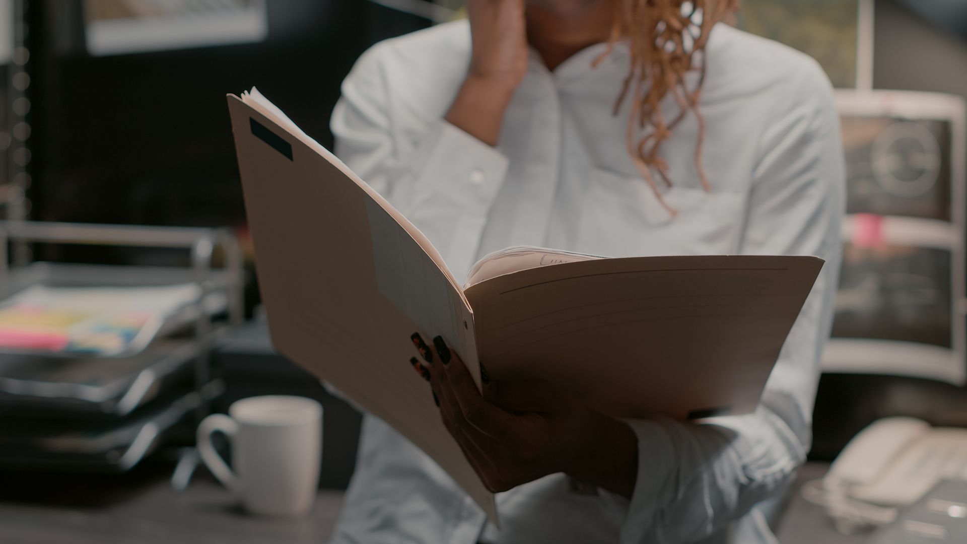 A woman in a white oxford shirt doing research on Michigan expungement law