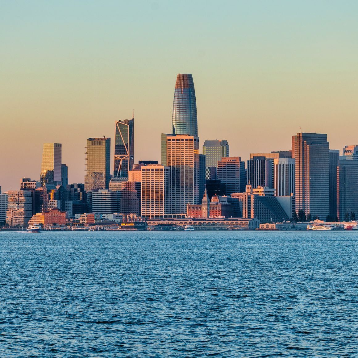 San Francisco skyline at sunset, with the Salesforce Tower prominently displayed over the bay.