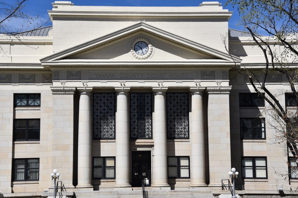 Historic white stone building with columns and a central clock above the entrance