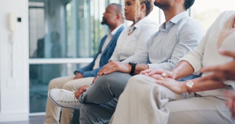 four individuals with a criminal record sitting in a waiting room ready for a job interview