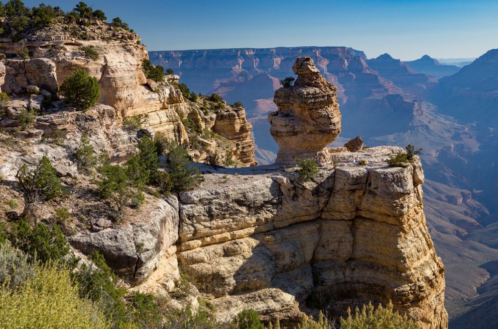 Rocky canyon cliffs and layered mesas under a clear blue sky