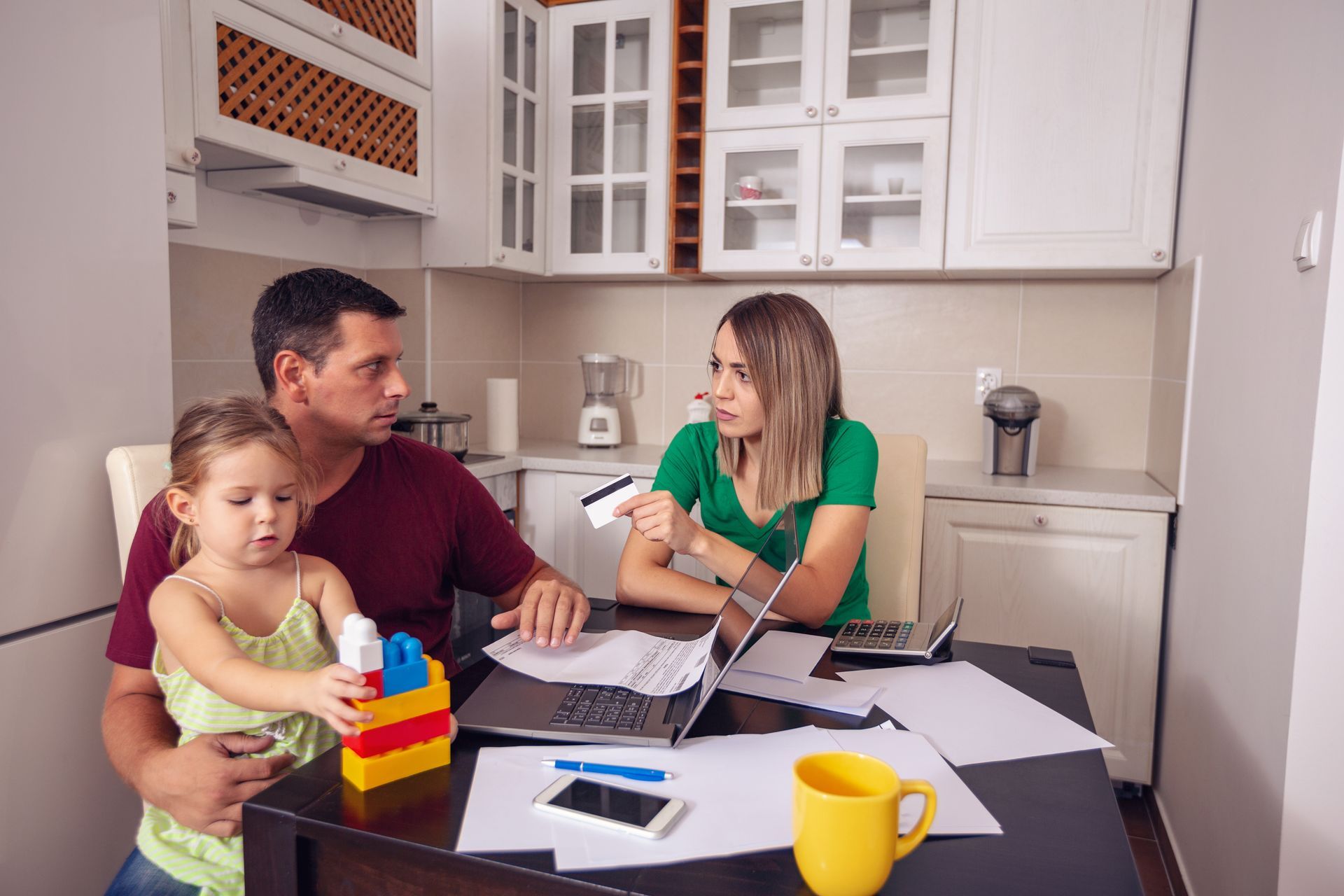 A young family sits at the table stressed about housing, with hope from California senate bill 460