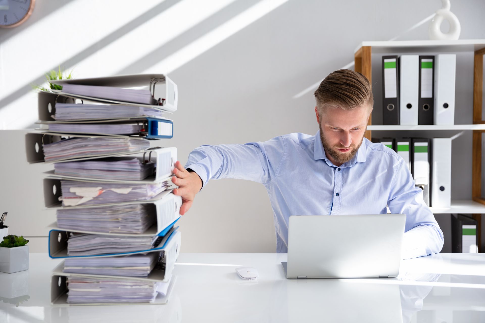 A CRA pushing a stack of binders off to the side in favor of digitally accessing public criminal records