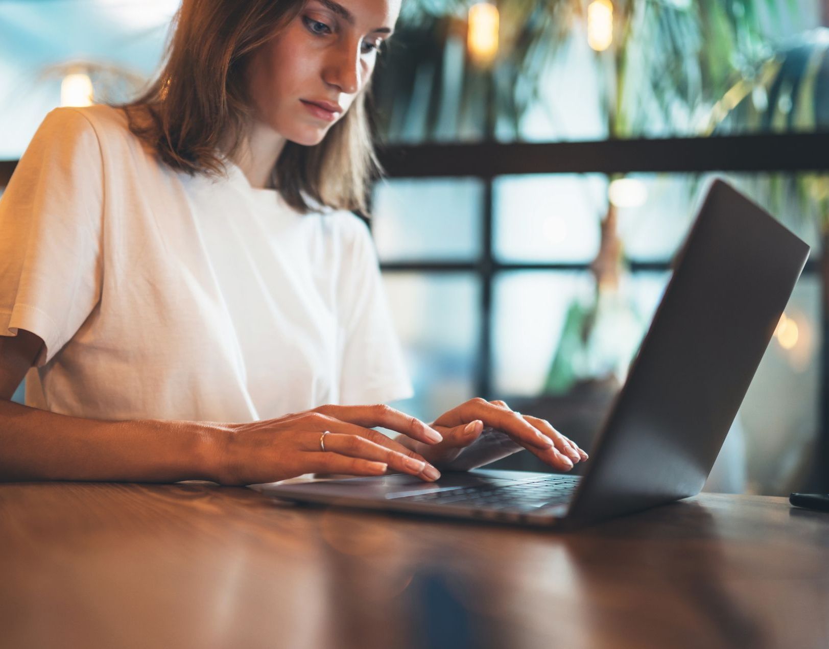 the cra sits in a coffee shop with her laptop, continuous backround checking for background screening trends