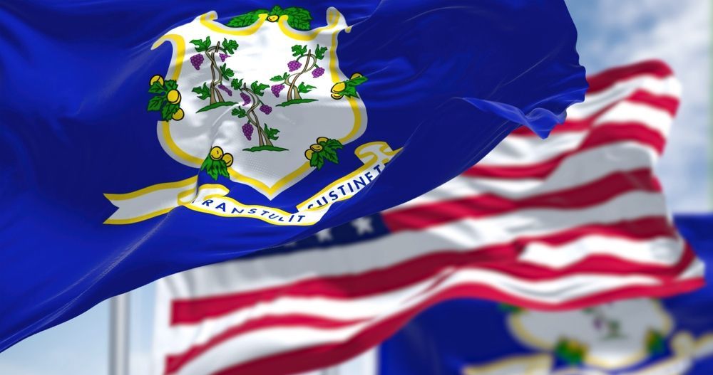 Connecticut state flag waving with an American flag in the background