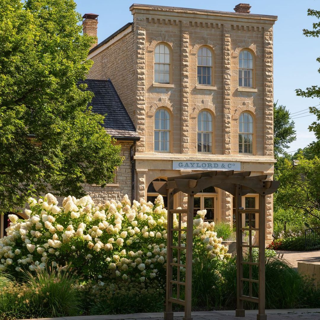 Three-story tan stone building with arched windows and